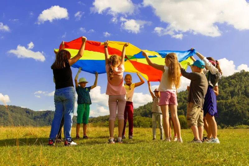 Children playing with brightly coloured parachute